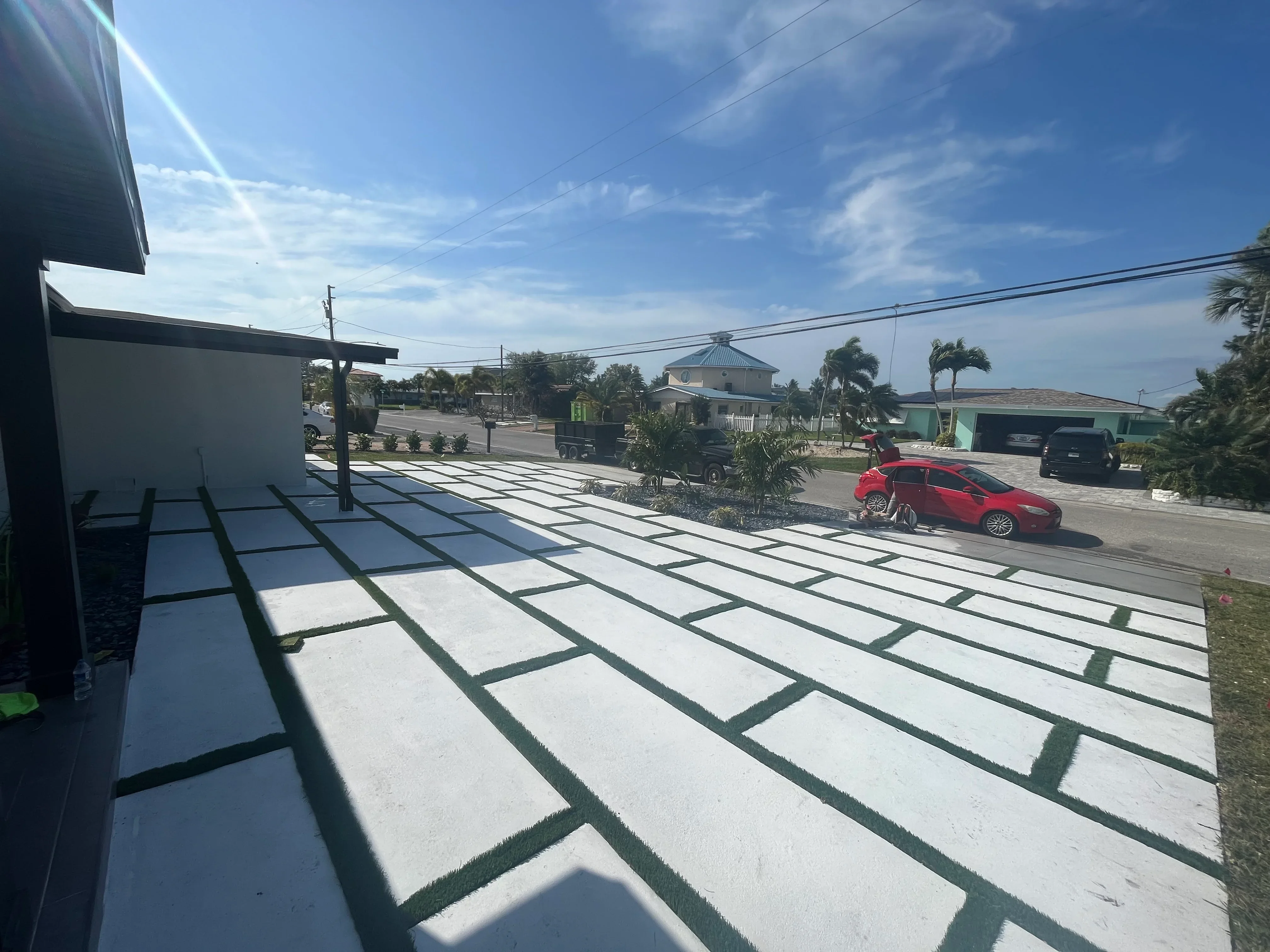 White concrete permeable pavers with grass joints in running bond pattern, residential driveway